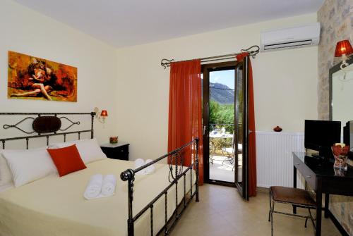 Schlafzimmer mit einem Bett, einem Schreibtisch und einem Fenster in der Unterkunft Byzantinon Hotel in Leonidi