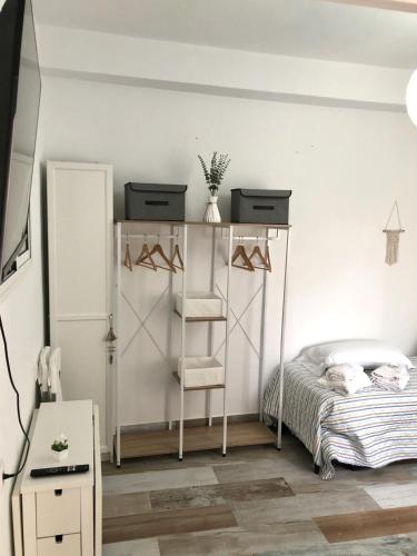 a bedroom with a bed and a shelf with hangers at Céntrico Rota Beach. in Rota