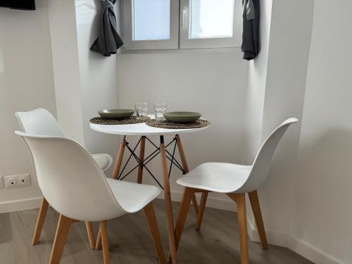 une salle à manger avec des chaises blanches et une table dans l'établissement Studio Cosy, 5 minutes du Palais des festivals, à Cannes