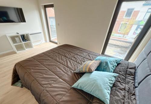 ein großes Bett in einem Zimmer mit einem großen Fenster in der Unterkunft Station 64 B2 Charleroi-Airport in Charleroi