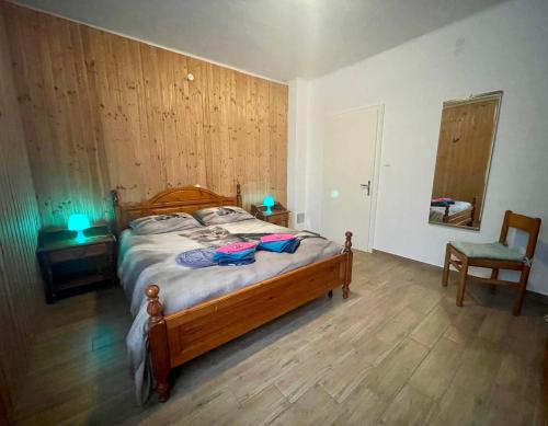 um quarto com uma cama de madeira e uma cadeira em Maggioni Silvia em Tarvisio