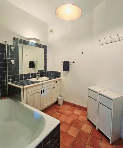 une salle de bain avec une baignoire, un lavabo et un miroir dans l'établissement TRES BEL APPARTEMENT VUE MER - Piscine - Tennis et Golf, à Saint-Cyr-sur-Mer
