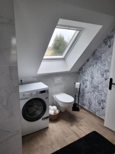 een badkamer met een wasmachine en een toilet bij Vers la crique de Bot-Conan in Fouesnant