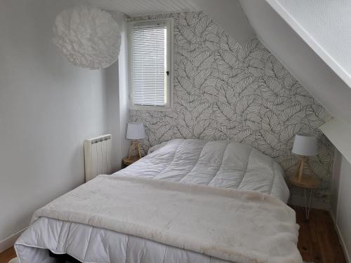 een witte slaapkamer met een bed en een trap bij Vers la crique de Bot-Conan in Fouesnant