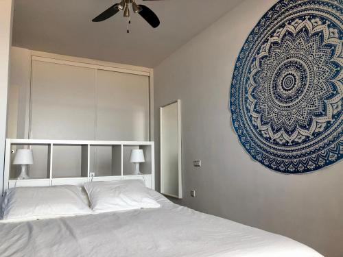 a bedroom with a white bed and a blue plate on the wall at Apartamento de Carboneras - Terrazas y Vistas in Carboneras