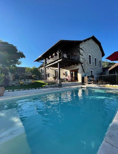 une grande piscine devant un immeuble dans l'établissement Le Clos Bô-m, à Marignieu