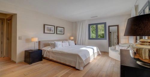 une chambre avec un grand lit avec des draps et des oreillers blancs dans l'établissement CYRIL Magnifique villa provençale, à Saint-Tropez