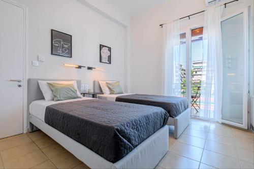 a bedroom with two beds and a balcony at Match Point Apartment, Corfu Town in Agios Rokkos