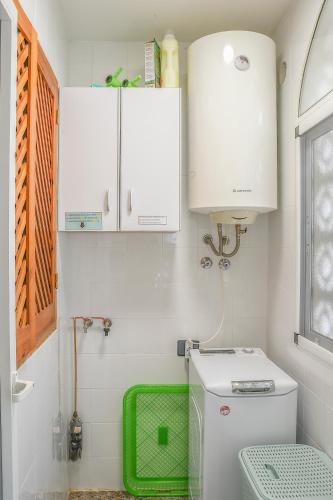 a bathroom with a white toilet and a green basket at La Casa de las Maravillas in Puerto de Mazarrón