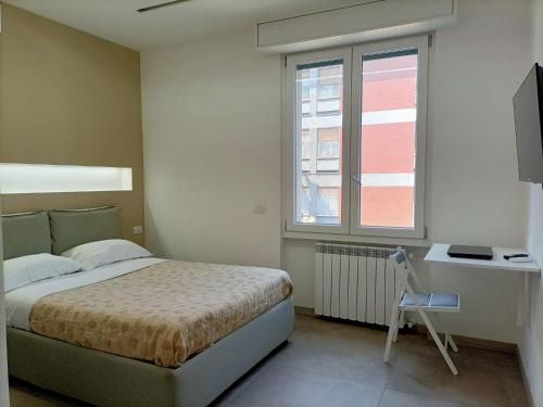 een slaapkamer met een bed, een bureau en een raam bij parea house 5 in Milaan