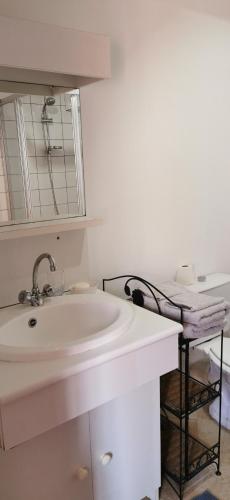 uma casa de banho branca com um lavatório e um espelho em Cottage LE NID em Perriers-en-Beauficel