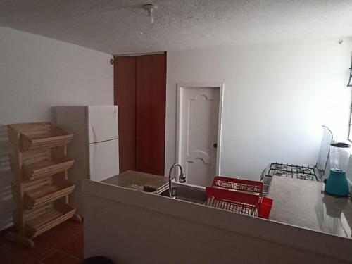 uma cozinha com um lavatório e um frigorífico em GARDENIAS SUITS em Ibarra