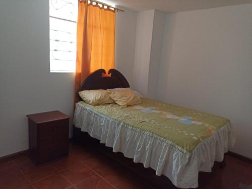 Dormitorio pequeño con cama y ventana en GARDENIAS SUITS, en Ibarra