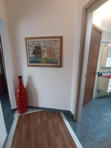 a red vase sitting next to a wall with a painting at Villa Patrizia in La Spezia