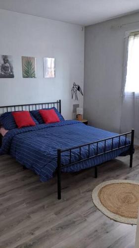 een slaapkamer met een bed met blauwe lakens en rode kussens bij Royal Parc 7 in Mougins