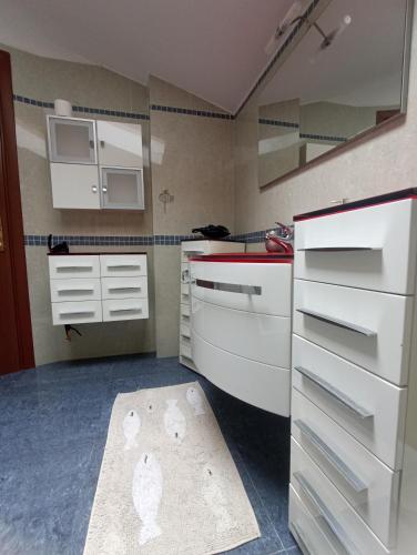a small kitchen with white cabinets and a sink at Villa Patrizia in La Spezia