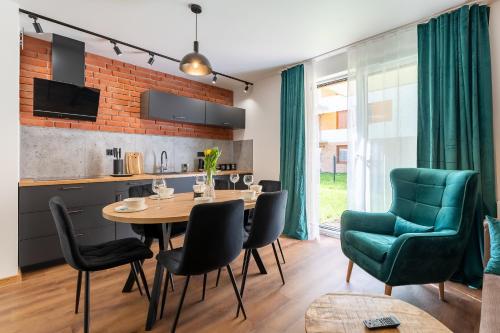 a kitchen and dining room with a table and chairs at Apartamenty w Karkonoszach- Apartament Lucky 7 z widokiem na Śnieżkę i ogródkiem in Karpacz