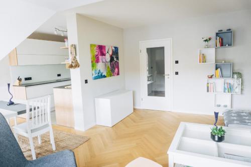 a living room with white walls and wooden floors at Design Apartment in Hallbergmoos in Hallbergmoos