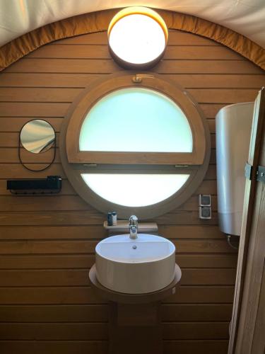Un baño pequeño con lavabo y ventana. en White Spring Glamping, en Câmpulung Moldovenesc