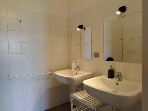 a bathroom with two sinks and a mirror at Lake Como Beach Hostel in Domaso