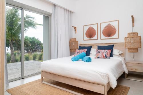 a bedroom with a large bed and a large window at Ocean Point Beachfront Residences - Apartment A1 in Pointe aux Piments