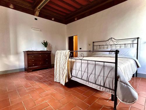 1 dormitorio con cama de metal y vestidor en Villa Mucellena, en Casole dʼElsa