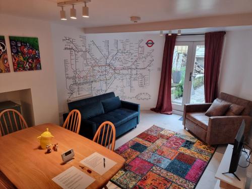 a living room with a table and a couch at Entire Ground Floor Flat, Free Off-Street Parking and Large Garden in London