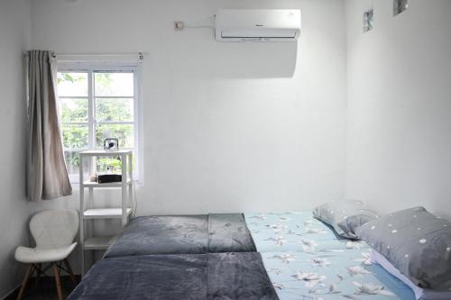1 dormitorio con cama, ventana y silla en Fanda Home Syariah en Cimanggu