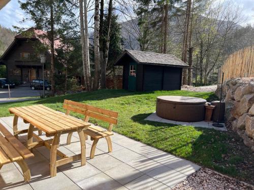 una mesa de picnic de madera y una bañera en un patio en Chalet Schäftal 