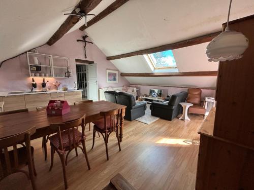 una sala da pranzo e un soggiorno con tavolo e sedie di La Maison du bonheur - Gîte RULINA - Corancy a Corancy