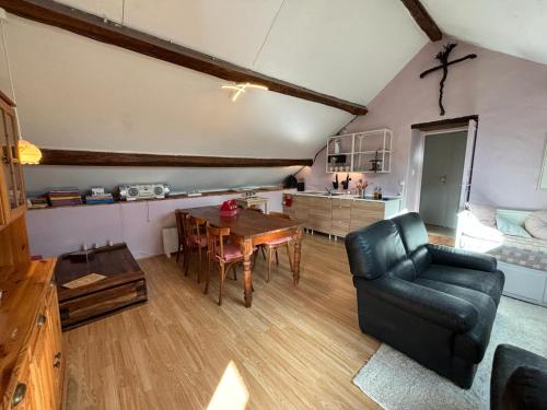 un soggiorno con tavolo e sedia in pelle di La Maison du bonheur - Gîte RULINA - Corancy a Corancy