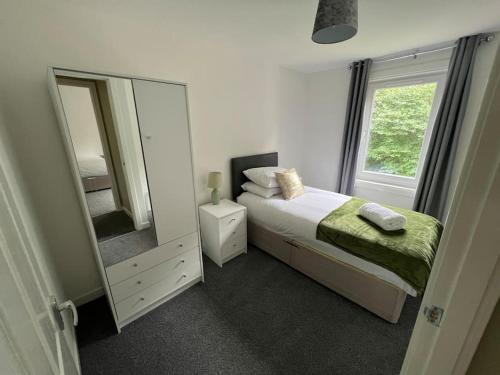 een slaapkamer met een bed en een grote spiegel bij 3 bedroom sleeps 4 in Glenrothes in Fife