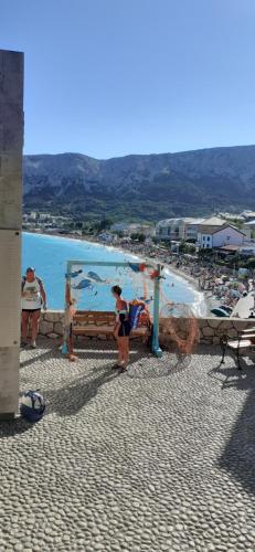 a group of people standing on a beach at Old Town Baska in Baška
