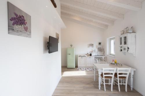una cucina con tavolo bianco e frigorifero verde di Lombardi Rita - Colle S. Martino ad Assisi