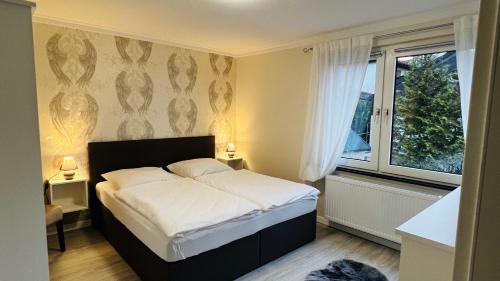 a bedroom with a bed and a large window at Maison Lily Apartment 4 in Bad Lauterberg