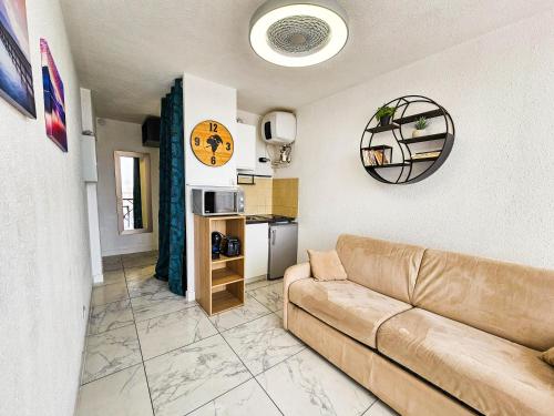 een woonkamer met een bank en een keuken bij CHARMANT studio proche de la mer in Le Grau-du-Roi