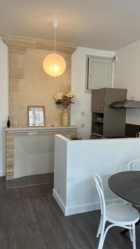 une cuisine avec un comptoir, une table et des chaises dans l'établissement Appartement de charme, à Bayeux