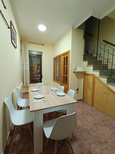 a dining room with a table and white chairs at Plaça de l'Almudí, where else! in Onda