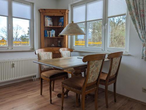 a dining room table and chairs with windows at Strandnest in Karlshagen