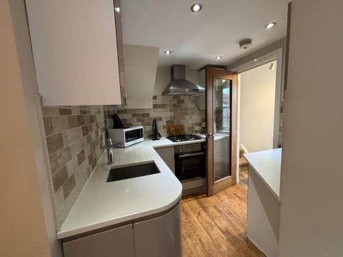 a kitchen with a sink and a stove top oven at Quirky cottage in the historical town of Beverley in Beverley