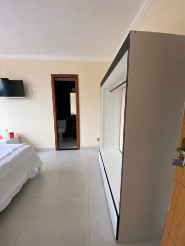 a bedroom with a bed and a sliding glass door at Suites O Vencedor in Búzios