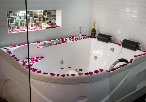 a bath tub filled with pink hearts and a bottle of wine at Hotel Risot in Bogotá