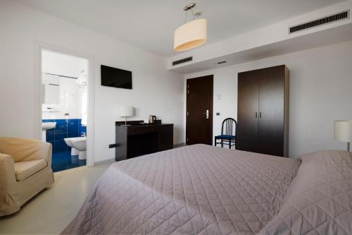 a bedroom with a bed and a chair and a desk at Hotel Sorriso in Venice-Lido