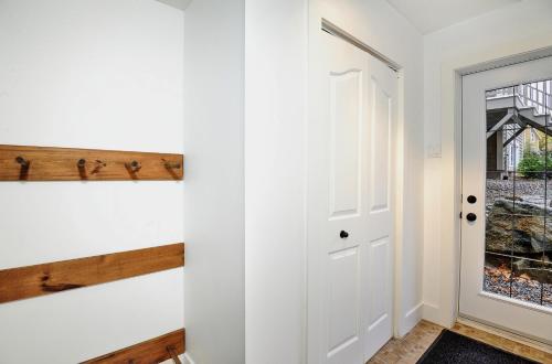 a hallway with a door and a window at Chalet 9029 Chemin des Alpages by Les Chalets Alpins in Stoneham
