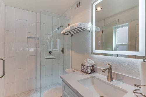 a white bathroom with a sink and a mirror at Big Bear Lake Condo with Deck, Steps to Ski Lift in Big Bear Lake