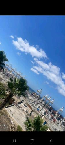widok na plażę z palmami i ocean w obiekcie Chambres Maya w mieście Ksar es-Seghir