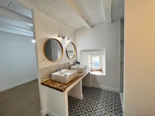 une salle de bain avec deux lavabos et un miroir dans l'établissement Maison de ville rénovée à 5 mn du Futuroscope, à Jaunay-Clan