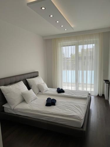 a bedroom with a large bed with two blue shoes on it at Lux Cordia Apartment with free parking in Budapest