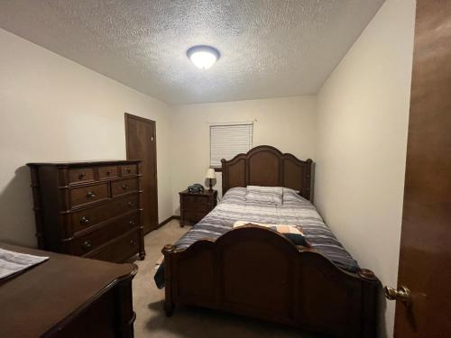 Ruby’s Retreat في Mount Gay: غرفة نوم مع سرير خشبي وخزانة