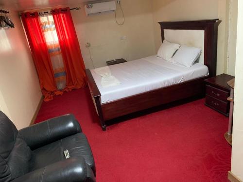 a small bedroom with a bed and a couch at Hotel La Rochelle in Bonamakolo